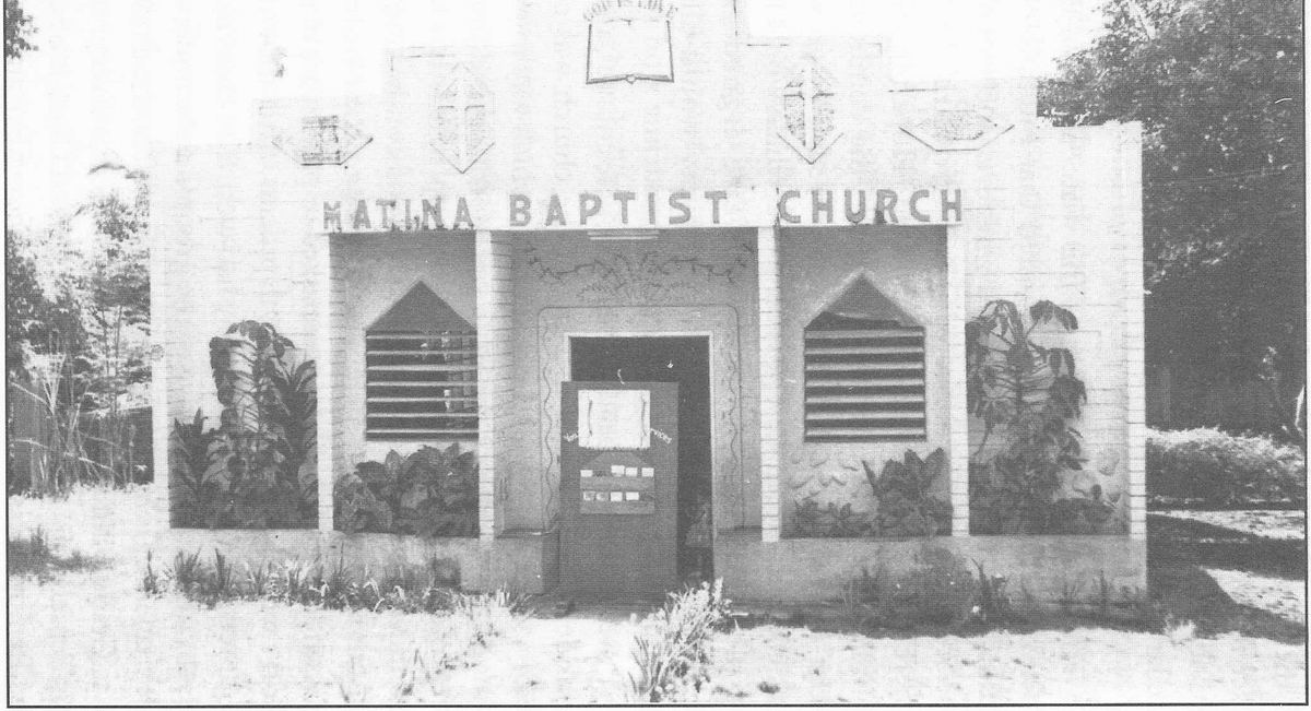 Small concrete chapel with a cross and the name Matina Baptist Church above the doors.