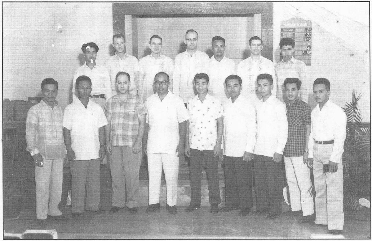 Group of missionaries and Filipino church workers standing together outdoors.