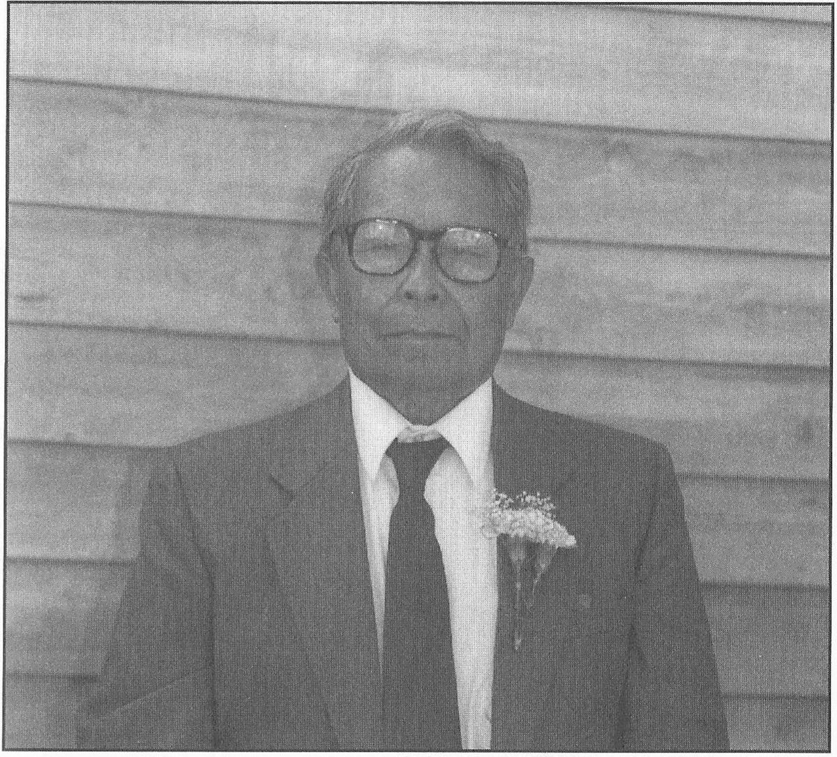 Portrait of Rev. Vicente T. Onggao in a dark suit with a boutonnière.
